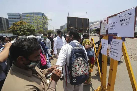 4月19日，人们聚集在印度孟买一处新冠疫苗接种中心门口的疫苗告罄通知前