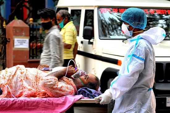 印度医护人员运送一名感染新冠病毒的患者。