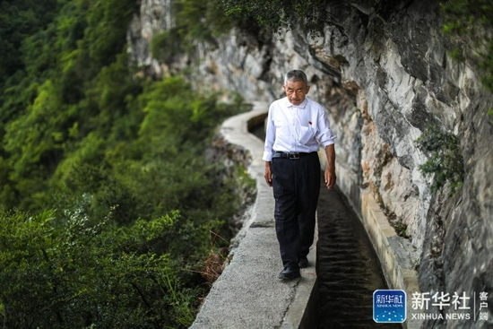 黄大发沿着修建在绝壁上的“大发渠”巡查（2018年8月11日摄）。新华社记者 刘续 摄