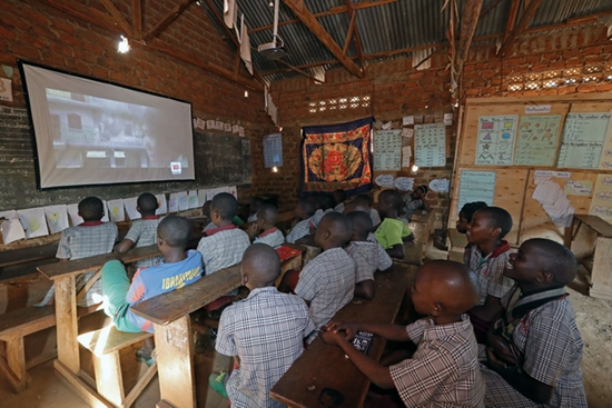 2018年8月14日，在乌干达瓦卡里坞学校，学生们在一起看电视。