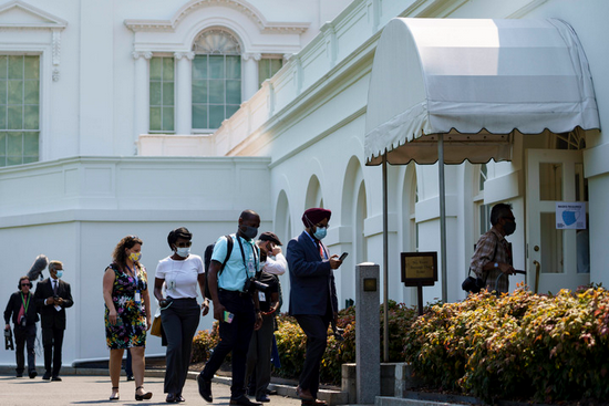 7月28日，在美国华盛顿白宫，记者们戴着口罩走向新闻简报室。新华社发（沈霆 摄）