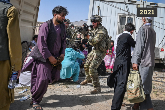 ▲2021年，“从实力地位出发”：在喀布尔卡尔扎伊国际机场，一名美军士兵咆哮着端起枪指向手无寸铁的阿富汗民众。