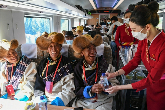 6月25日，全长435公里、设计时速160公里的拉林铁路建成通车，西藏首条电气化铁路建成，同时复兴号实现对31个省区市全覆盖。这是列车员向乘坐首趟复兴号高原内电双源动车组的乘客递水。新华社记者 普布扎西 摄