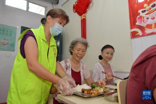  2020年7月29日，在江西省南昌市东湖区彭家桥街道文教路北社区，“幸福食堂”的义工在给就餐的老年人端上营养餐。新华社记者 彭昭之 摄