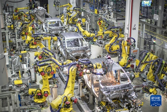 在重庆金康新能源汽车有限公司，智能化焊接机器人在进行焊接作业（2021年4月2日摄）。新华社记者 黄伟 摄