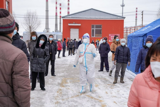  ↑11月10日，在黑河市爱辉区一小区，社区工作人员（中）组织居民排队领取免费生活物资。