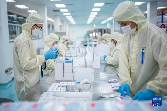  10月5日，在马来西亚吉隆坡郊区的发马公司灌装工厂，工人在包装本地灌装生产的科兴疫苗。新华社记者 朱炜 摄