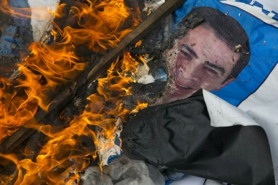 ·洪都拉斯抗议者焚烧的胡安·埃尔南德斯的画像。