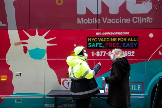 12月7日，在美国纽约，新冠疫苗接种车的工作人员与一名女士交谈。新华社记者 王迎 摄