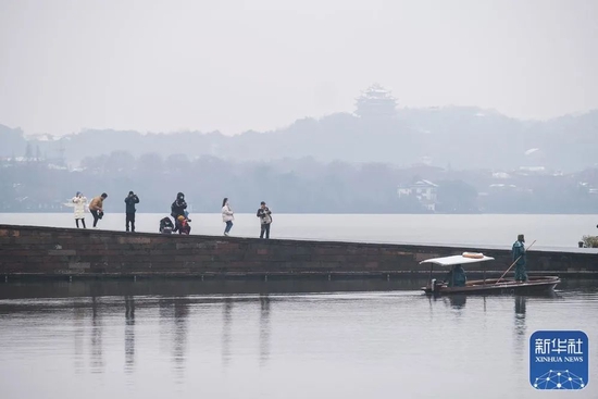 1月29日，游客在西湖景区的白堤上赏雪。