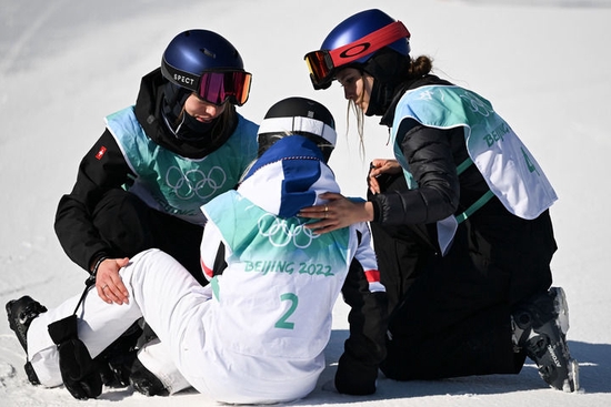 2月8日，中国选手谷爱凌（右）和瑞士选手玛蒂尔德·格雷莫德（左）在自由式滑雪女子大跳台决赛后安慰法国选手泰丝·勒德。新华社记者 薛宇舸 摄