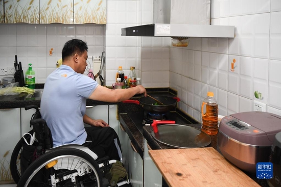 湖南省长沙市天心区家中，徐经卓在定制低位灶台上炒菜（2021年8月25日摄）。新华社记者 薛宇舸 摄