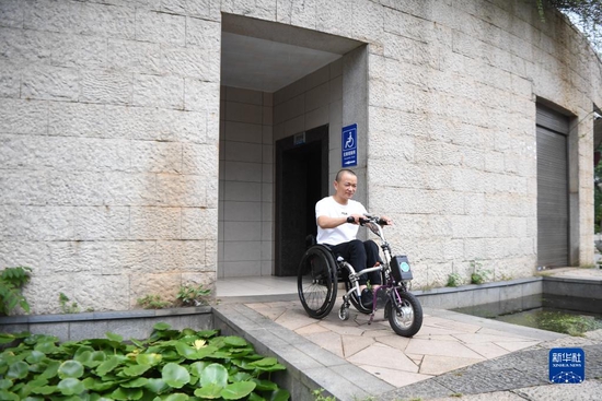 在湖南省长沙市湘府文化公园，刘毅坐电动轮椅车从无障碍洗手间出来（2021年8月25日摄）。新华社记者 薛宇舸 摄