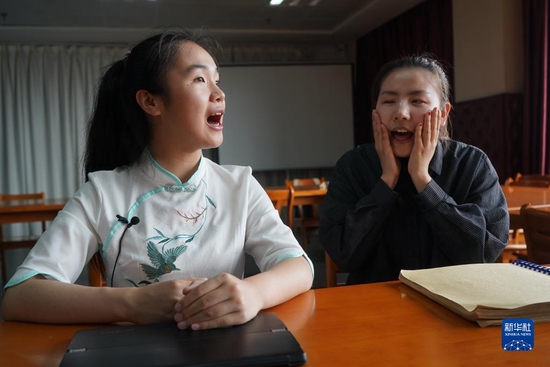 在南京特殊教育师范学院盲人图书室，盲人学生周文晴（左）在帮助盲人同学纠正普通话发音（2019年5月17日摄）。新华社记者 季春鹏 摄