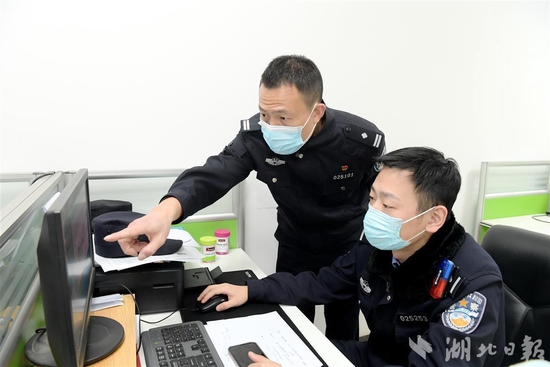 图为：邵玉春（左）和同事分析辖区治安情况