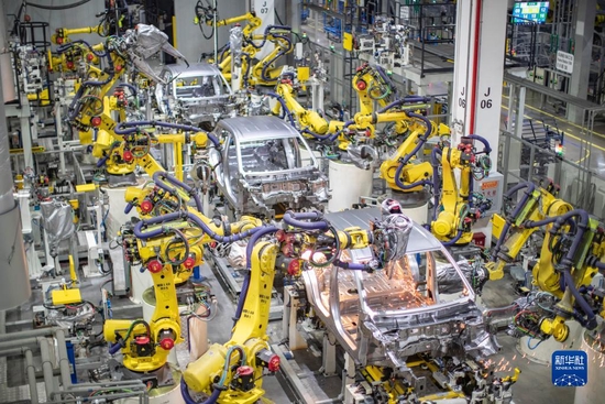 重庆一家新能源汽车企业使用智能化焊接机器人进行焊接作业（2021年4月2日摄）。 新华社记者 黄伟 摄