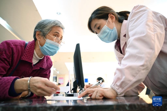 福建省三明市第一医院的医保办工作人员（右）向前来咨询药品报销问题的居民讲解相关政策（2020年11月18日摄）。 新华社记者 姜克红 摄