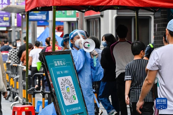 3月13日，志愿者在深圳罗湖区东门广场核酸检测点引导居民。新华社发（储焱 摄）