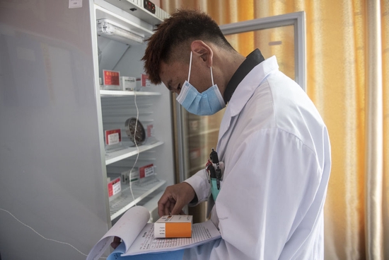 米玛次仁在林芝市巴宜区更章乡卫生院清点疫苗库存情况（2021年12月24日摄）。新华社记者 孙瑞博 摄