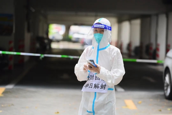 3月18日，深圳南山区沙河街道，一名抗疫工作人员坚守岗位。14日起，一向以快节奏著称的深圳开启为期一周的“慢生活”节奏。中新社记者 陈文 摄