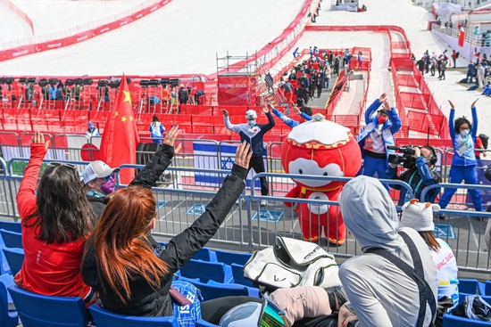 　3月10日，在延庆国家高山滑雪中心，观众在开赛前与“雪容融”互动。新华社记者江汉摄