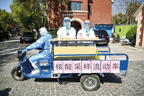 2022年4月4日，上海奉贤区金海街道南郊美墅小区，来自浙江湖州市吴兴区的援沪医务人员坐上“流动采样车”，挨家挨户为居民做核酸。图/人民视觉