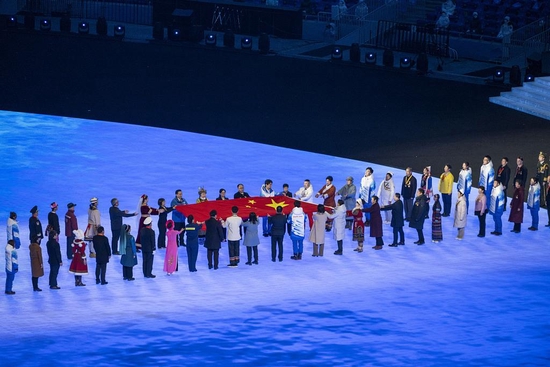  △2月4日，2022北京冬奥会开幕式在国家体育场举行。鸟巢中央，一面五星红旗在12位小朋友手中徐徐展开。随后，他们将国旗传递给176名代表。