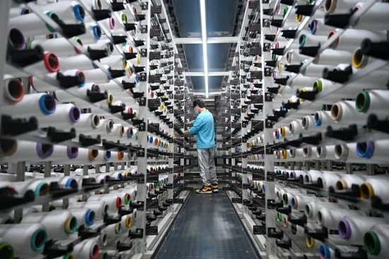  4月12日，在福建泉州石狮市的一家纺织企业，工人在工厂里忙碌。新华社发（周义摄）