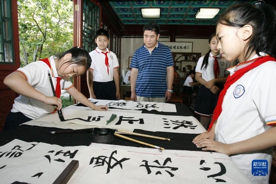  嘉宾在观看北京海淀区民族小学书法社团活动（2019年5月29日摄）。新华社记者 刘莲芬 摄