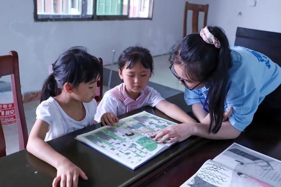 青年志愿者在重庆酉阳县青少年之家为儿童讲读绘本故事。