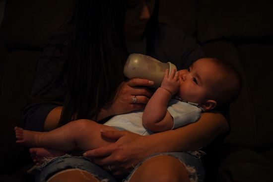 2022年5月19日，美国德克萨斯州休斯敦，一位母亲在家用奶粉喂食她5个月的女儿。图|IC photo