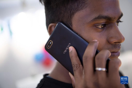 2019年10月8日，一名男子在印度金奈的一家商场使用中国品牌的手机。新华社记者 吕小炜 摄