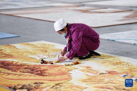 2021年6月7日，在青海圣源地毯集团有限公司生产车间内，工人在制作藏毯。新华社记者 张龙 摄