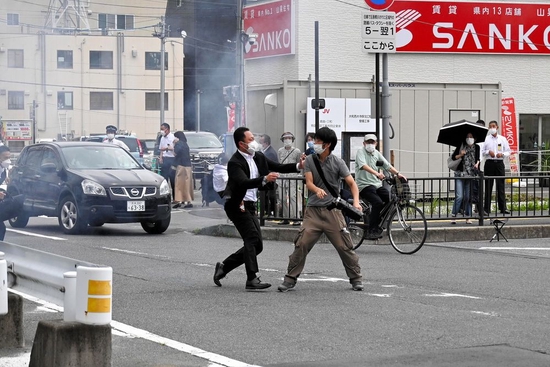  2022年7月8日，日本奈良市，安倍保镖试图捕捉一名疑似向安倍晋三开枪的男子（右）。