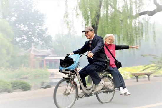 潘际銮骑电动自行车载着夫人李世豫在清华大学校园里。图/受访者提供