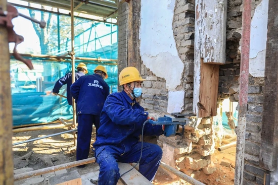 2020年11月10日，万寿寺，木工用电锯切除柱子腐烂的部分，然后换上与原柱材质规格相同的木材，做出榫卯的结构搭接。