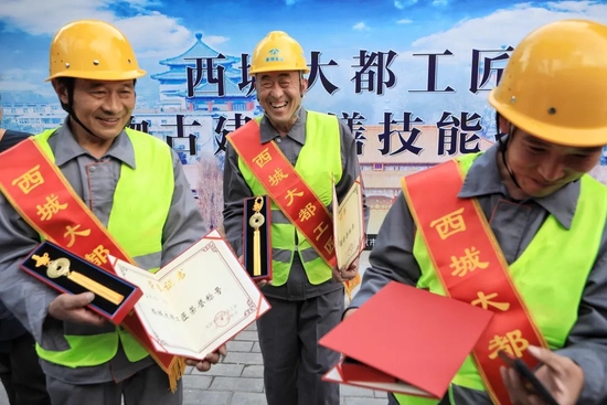 2021年4月28日，庆云寺，2021年“大都工匠”文物古建修缮技能技艺大赛决赛现场，获胜工人拿到奖状和奖牌。
