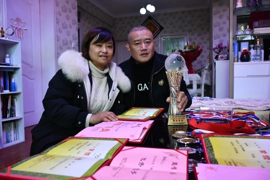 2月7日， 张琳艳父母展示女儿成长中获得的奖状及奖杯（新华社供图）