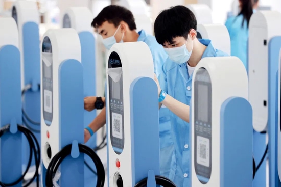 6月6日，浙江湖州市德清县一家公司的生产车间，工人赶制新能源汽车智能无线充电桩。图/视觉中国