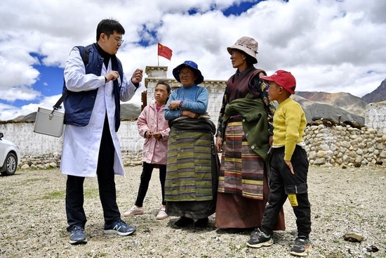 在西藏拉萨市当雄县格达乡格达村，第六批医疗人才“组团式”援藏专家王克明（左一）为村民讲解健康知识（2021年6月19日摄）。新华社记者 张汝锋 摄