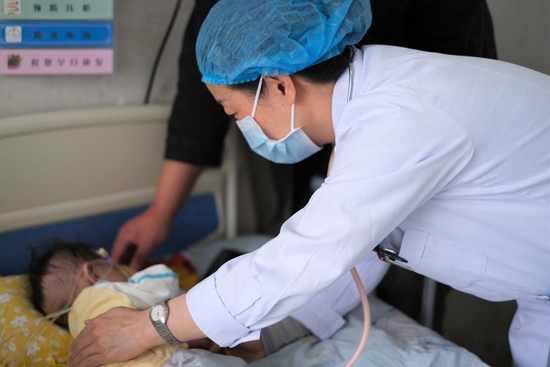 青海省妇女儿童医院医生、青南支医队员孙敬在青海省玉树藏族自治州人民医院给患者检查身体（2022年4月25日摄）。新华社记者 韩方方 摄
