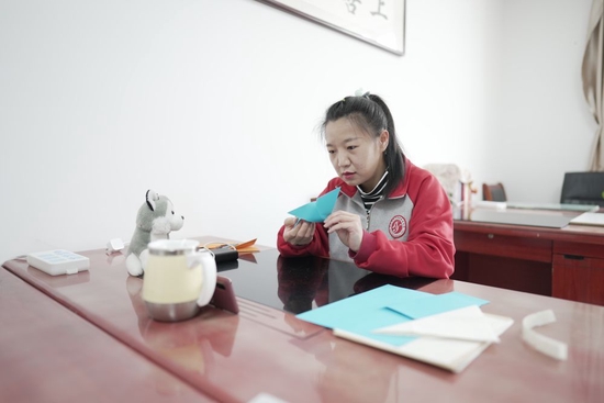 王雅妮在内蒙古呼和浩特市特殊教育学校的办公室里给学生们上网课（2022年4月28日摄）。新华社记者 达日罕 摄