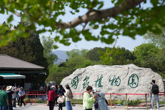 游客在位于北京的国家植物园入口处参观（2022年4月18日摄）。新华社记者 鞠焕宗 摄