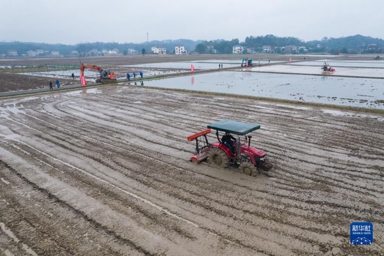 在湖南省常德市桃源县浔阳街道大平村，工作人员驾驶农机平整土地（2022年2月17日摄，无人机照片）。新华社记者 陈思汗 摄