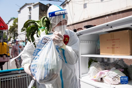  在湖南省长沙市雨花区东塘街道枫树山社区，志愿者把生活物资放进无人车，助力解决物资配送“最后一公里”问题（2022年4月7日摄）。新华社记者 陈思汗 摄