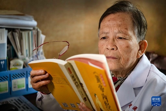 在陕西佳县中医院门诊义诊的路生梅，没有病人时坚持看书学习（2020年4月8日摄）。新华社记者 陶明 摄