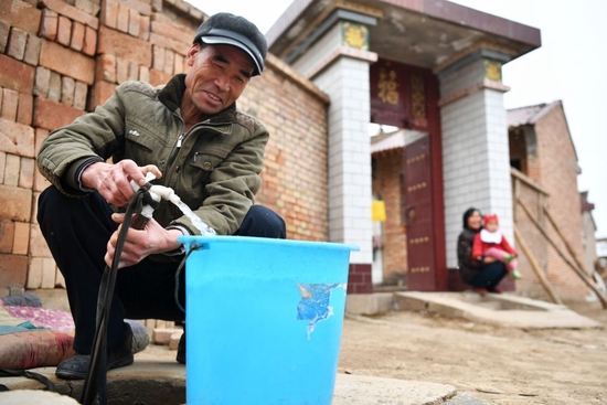 ↑2018年12月21日，甘肃省平凉市庄浪县柳梁镇孟山村村民孟述东在自家门口用自来水管取水。2018年以来，平凉市庄浪县在自来水通村全覆盖的基础上，大力推进农村饮水安全巩固提升工程，确保农村群众尤其是山区群众在冬季低温天气下正常用水。
