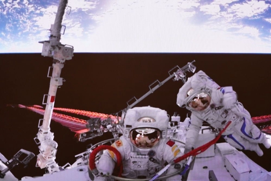 2022年9月2日在北京航天飞行控制中心拍摄的神舟十四号航天员刘洋（左）结束出舱任务正在返回的画面。新华社发（李杰摄）