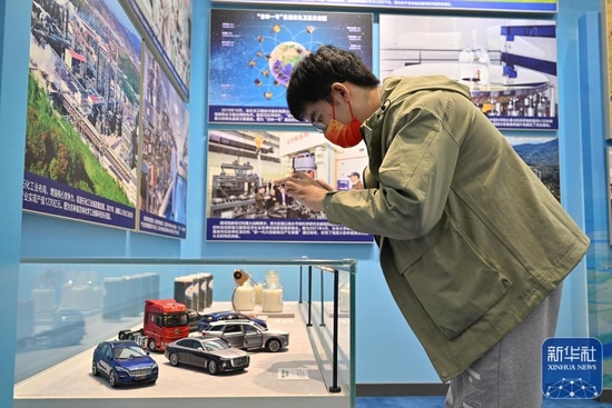 10月8日，一名观众在吉林展区拍摄中国第一汽车集团有限公司自主品牌汽车模型。新华社记者 李鑫 摄