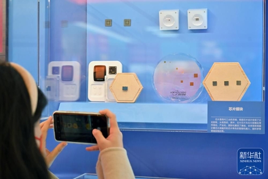 10月8日，一名观众拍摄名为“方寸之间”的陈列墙上的芯片模块展示。新华社记者 李鑫 摄